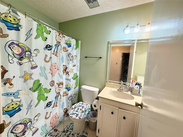 full bathroom featuring a shower with curtain, vanity, toilet, visible vents, and a textured ceiling