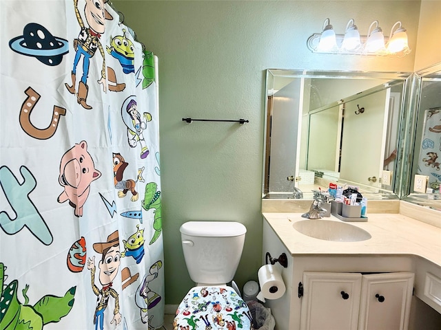 bathroom featuring a shower with shower curtain, toilet, a textured wall, and vanity