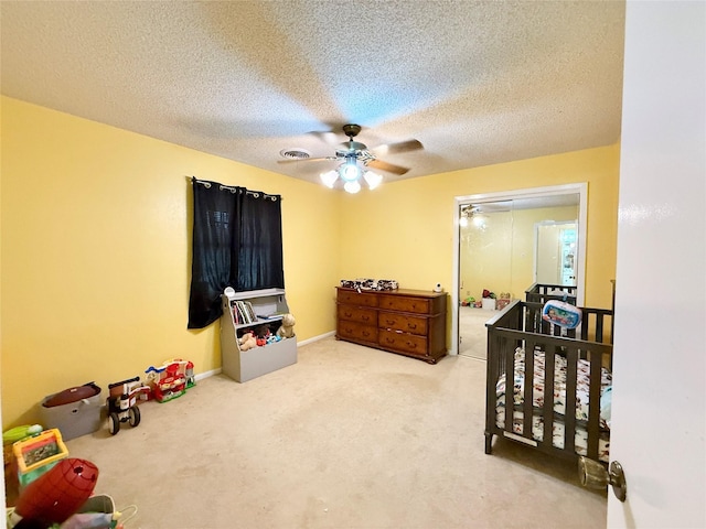 bedroom with visible vents, ceiling fan, carpet floors, and a textured ceiling