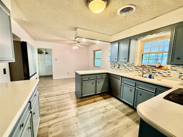 kitchen with visible vents, black appliances, a peninsula, and a textured ceiling