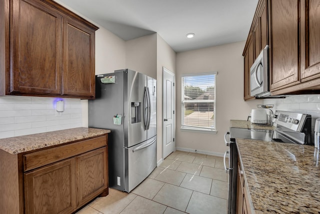 2112 Atlantic Ave, Anna, TX 75409 - kitchen featuring baseboards, light stone counters, light tile patterned floors, decorative backsplash, and stainless steel appliances