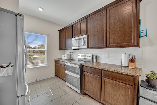 2112 Atlantic Ave, Anna, TX 75409 - kitchen featuring tasteful backsplash, light tile patterned floors, baseboards, appliances with stainless steel finishes, and light stone countertops