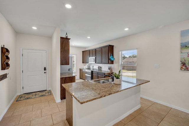 2112 Atlantic Ave, Anna, TX 75409 - kitchen with a sink, light tile patterned floors, appliances with stainless steel finishes, and light stone countertops