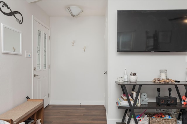corridor with dark wood-type flooring and baseboards