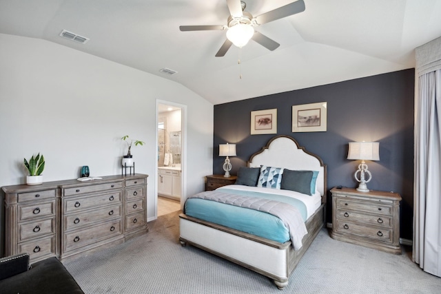 bedroom with visible vents, ensuite bath, vaulted ceiling, and light colored carpet