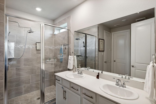 full bathroom featuring double vanity, a sink, and a stall shower