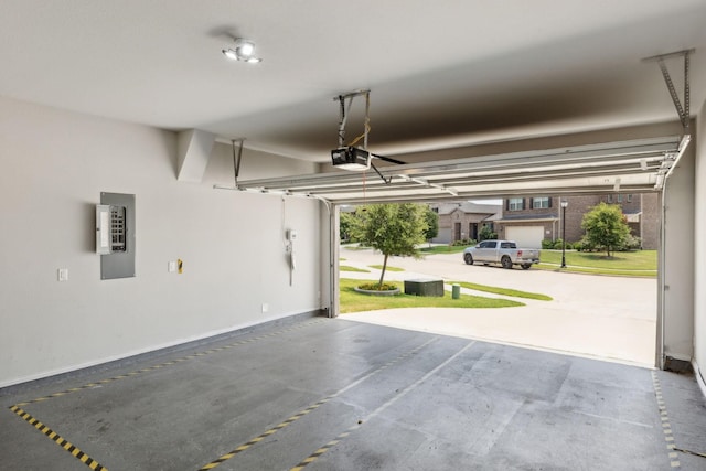 garage with baseboards, a garage door opener, and electric panel