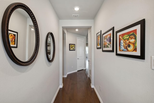corridor featuring baseboards, visible vents, and dark wood-type flooring