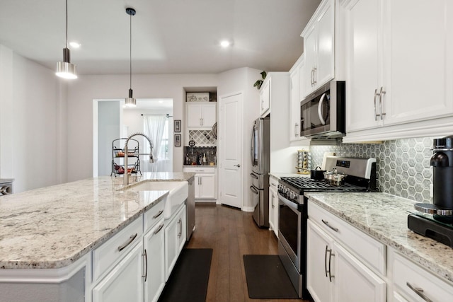 kitchen with dark wood-type flooring, a sink, white cabinetry, and appliances with stainless steel finishes