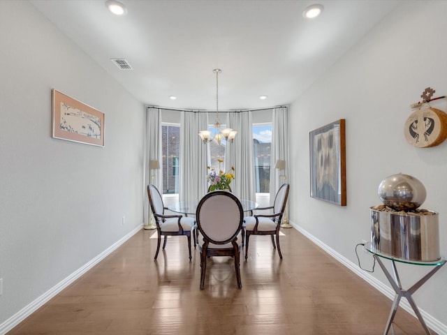 dining space featuring an inviting chandelier, recessed lighting, wood finished floors, and visible vents