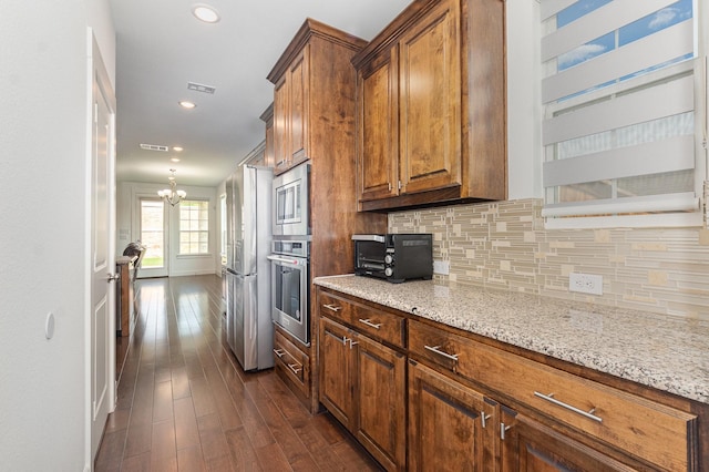760 Durham St, Allen, TX 75013 - kitchen with stainless steel appliances, dark wood finished floors, decorative backsplash, a chandelier, and light stone countertops