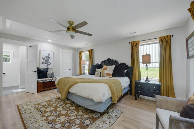 bedroom featuring attic access, multiple windows, visible vents, and light wood-type flooring