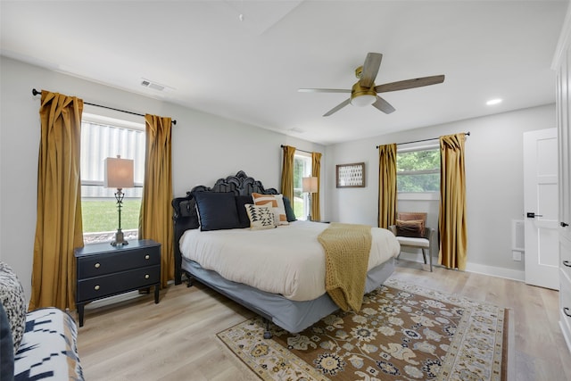bedroom with a ceiling fan, light wood-style floors, and visible vents