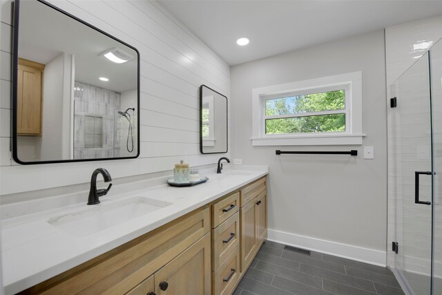 bathroom with baseboards, tile patterned floors, a sink, and a stall shower