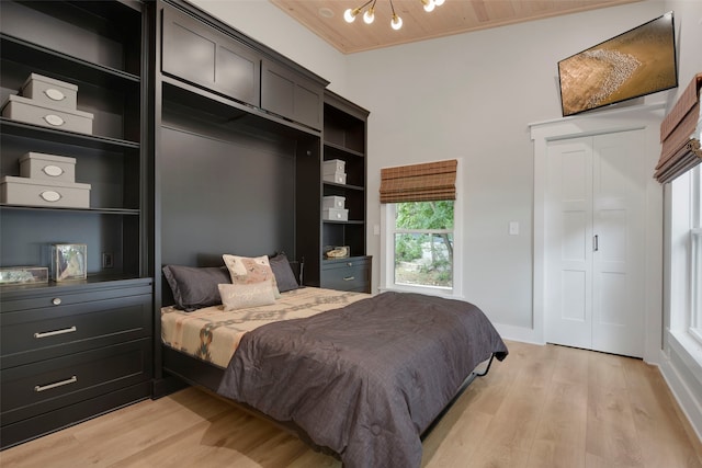 bedroom featuring wood ceiling, a chandelier, and light wood finished floors