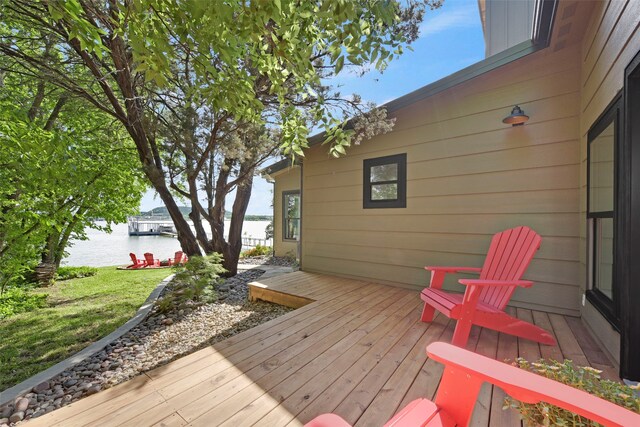 wooden deck with a lawn and a water view