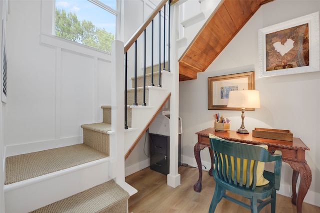 stairs featuring vaulted ceiling, baseboards, and wood finished floors