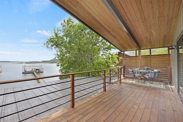 wooden terrace with outdoor dining area and a water view