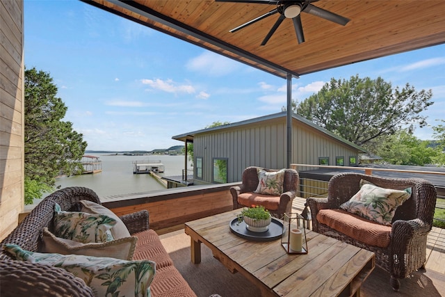 view of patio with outdoor lounge area, a ceiling fan, and a water view