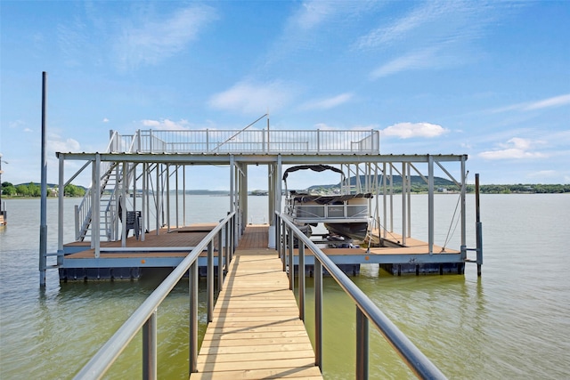 dock area featuring boat lift and a water view