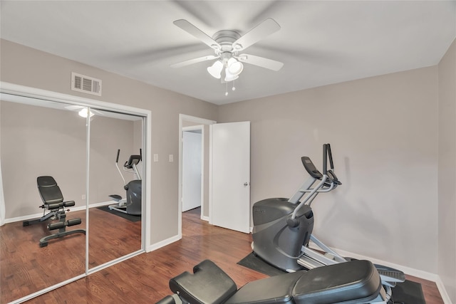 workout room featuring wood finished floors, ceiling fan, baseboards, and visible vents