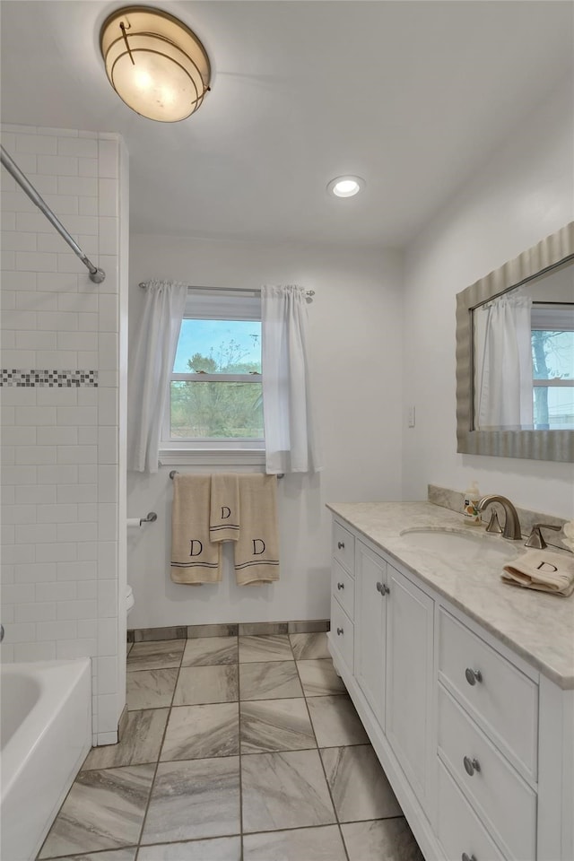 full bath with a wealth of natural light, recessed lighting, vanity, and toilet