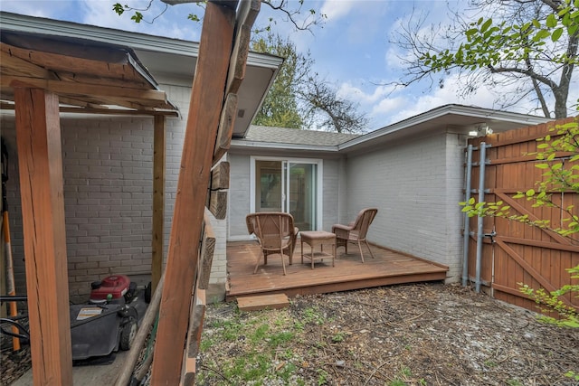 view of patio / terrace with fence, a wooden deck, and a gate