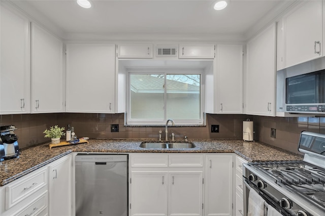 kitchen with appliances with stainless steel finishes, a sink, and white cabinets