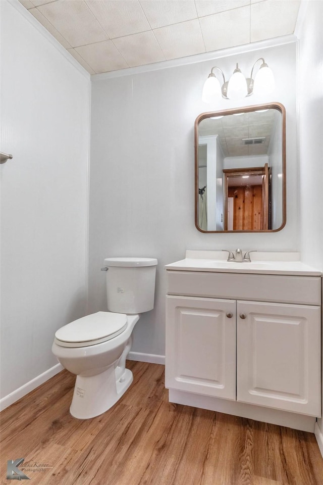 509 Reeves St, Clyde, TX 79510 - bathroom featuring toilet, vanity, wood finished floors, and baseboards