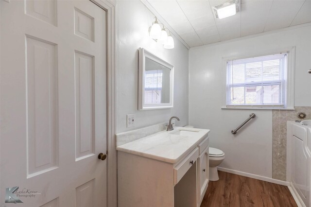 509 Reeves St, Clyde, TX 79510 - bathroom with wood finished floors, toilet, vanity, and baseboards