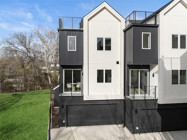 back of house featuring an attached garage, a lawn, stucco siding, and concrete driveway