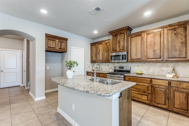 4301 Blackjack Oak Dr, Mckinney, TX 75070 - kitchen featuring appliances with stainless steel finishes, a sink, arched walkways, decorative backsplash, and recessed lighting