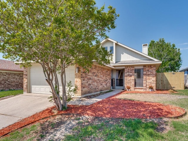view of front of home with a chimney, driveway, an attached garage, brick siding, and fence