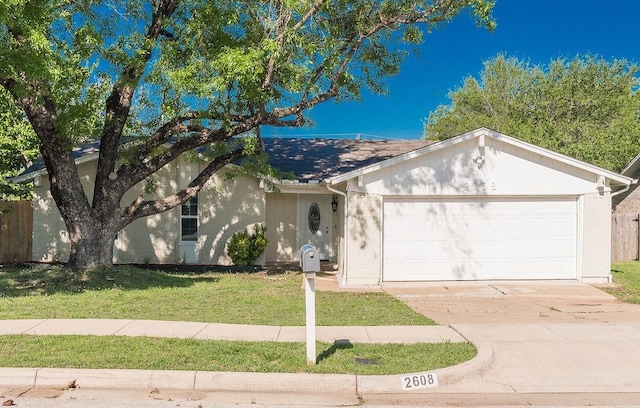 ranch-style home featuring a front yard, an attached garage, and driveway
