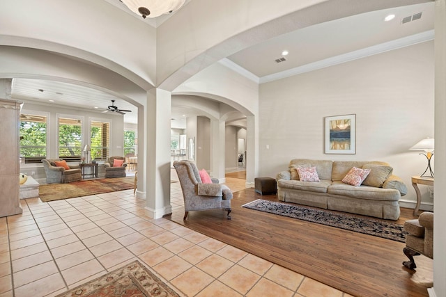 1406 Jacob Ave, Keller, TX 76248 - living area featuring light tile patterned floors, a ceiling fan, crown molding, visible vents, and arched walkways