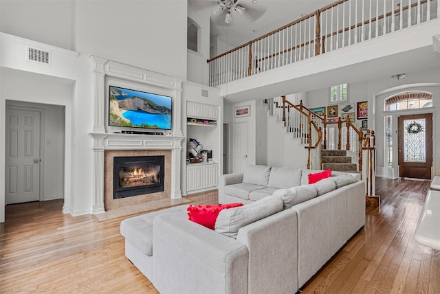 1870 Hillcroft Dr, Rockwall, TX 75087 - living room featuring a ceiling fan, visible vents, stairway, a towering ceiling, and light wood-style floors