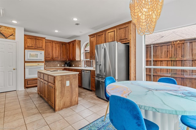 1870 Hillcroft Dr, Rockwall, TX 75087 - kitchen with light tile patterned floors, a center island, stainless steel appliances, light countertops, and decorative backsplash