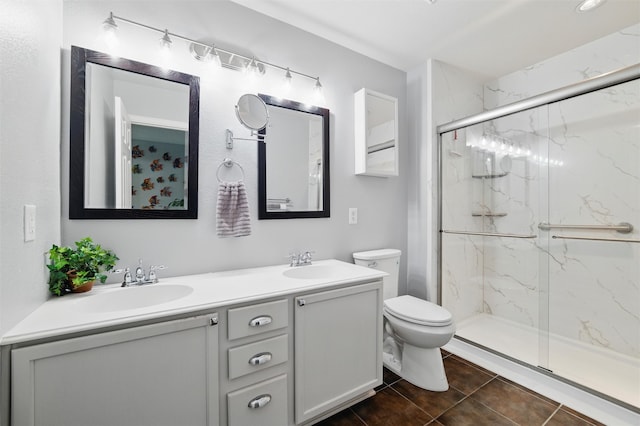 full bath with toilet, a sink, a marble finish shower, and double vanity
