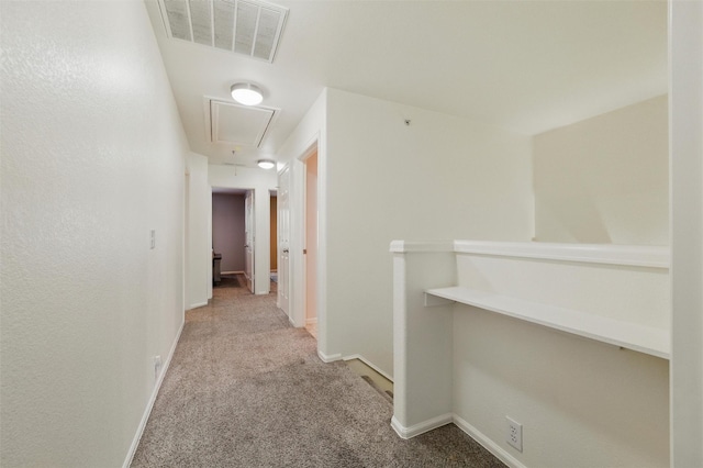 corridor with attic access, visible vents, carpet floors, and baseboards