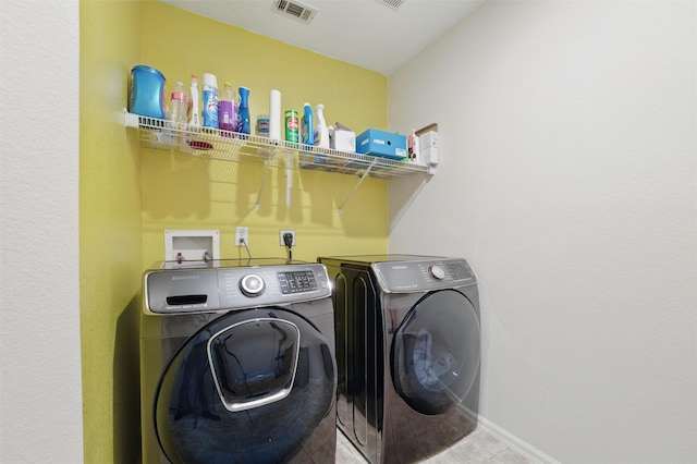 clothes washing area featuring tile patterned floors, baseboards, visible vents, independent washer and dryer, and laundry area