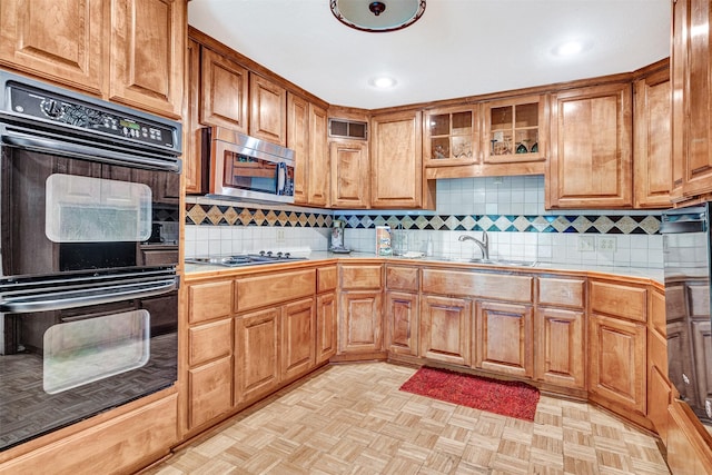 kitchen featuring backsplash, black appliances, visible vents, tile countertops, and a sink