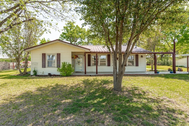 ranch-style house featuring a front yard and metal roof