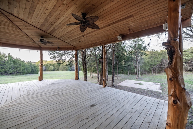 wooden deck featuring a ceiling fan and a yard