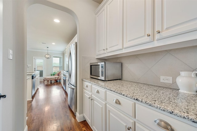 781 Bosley Dr, Fate, TX 75087 - kitchen with stainless steel appliances, ornamental molding, white cabinets, decorative backsplash, and dark wood-style floors