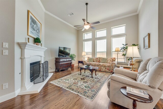 781 Bosley Dr, Fate, TX 75087 - living room with ceiling fan, wood finished floors, crown molding, baseboards, and a fireplace with raised hearth