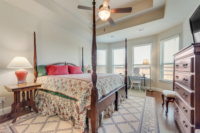 781 Bosley Dr, Fate, TX 75087 - bedroom featuring baseboards, multiple windows, wood finished floors, and a raised ceiling