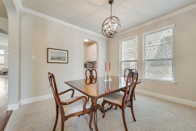 781 Bosley Dr, Fate, TX 75087 - dining space featuring arched walkways, light colored carpet, baseboards, crown molding, and a chandelier