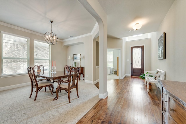 781 Bosley Dr, Fate, TX 75087 - dining space with arched walkways, plenty of natural light, a chandelier, baseboards, and crown molding