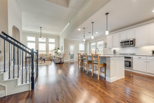 781 Bosley Dr, Fate, TX 75087 - kitchen with stainless steel appliances, crown molding, ceiling fan, an island with sink, and white cabinetry