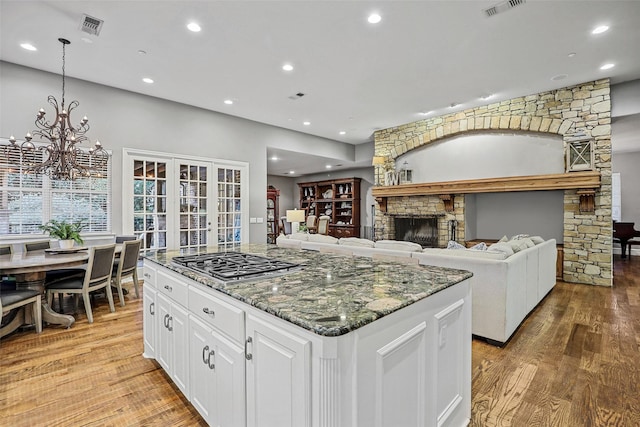 10040 Little Horn Cir, Frisco, TX 75035 - kitchen featuring stainless steel gas stovetop, light wood-style floors, a center island, white cabinetry, and recessed lighting